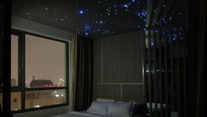 A bedroom with a large window, a bed, and a view of the cityscape. - The GoldView Luxury Apartment (Ho Chi Minh City)