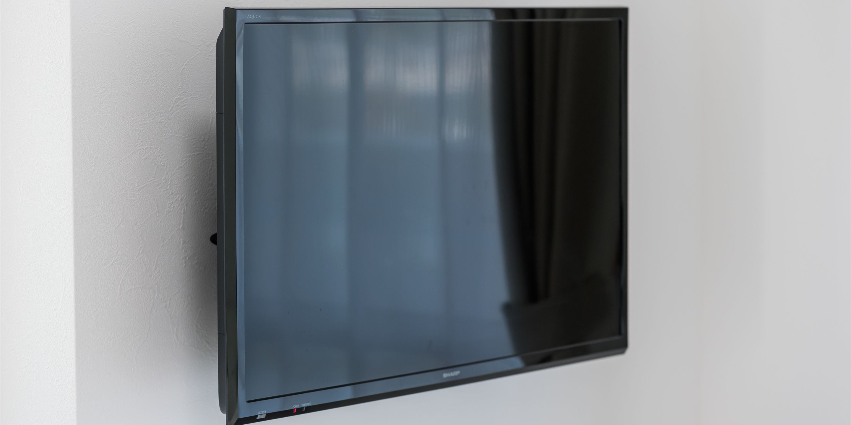 A flat-screen TV mounted on a white wall.