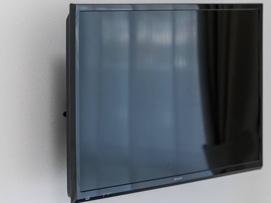 Un televisor de pantalla plana montado en una pared blanca.