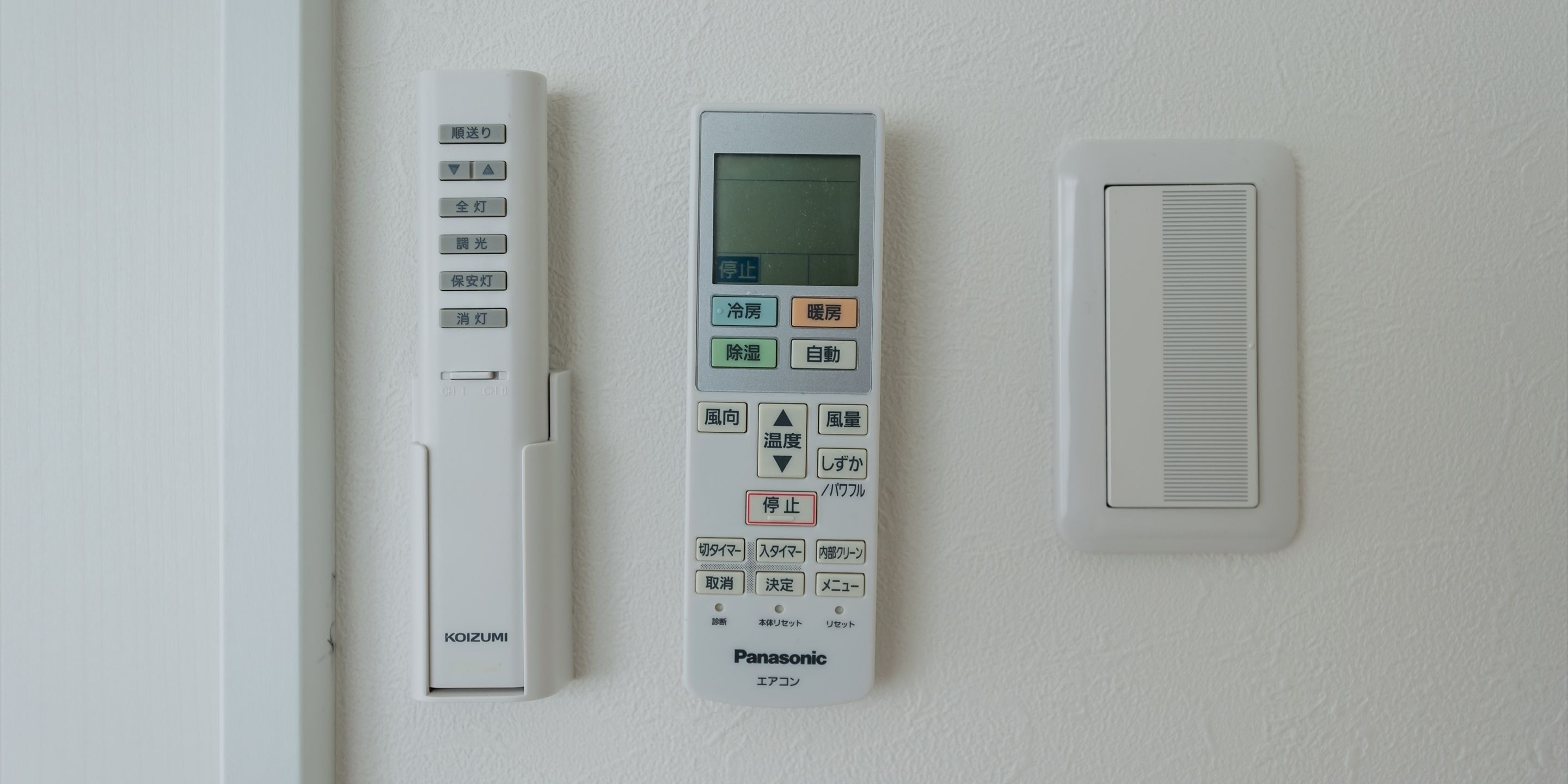 A wall-mounted thermostat with a digital display, a control panel with various settings, and a ventilation unit.
