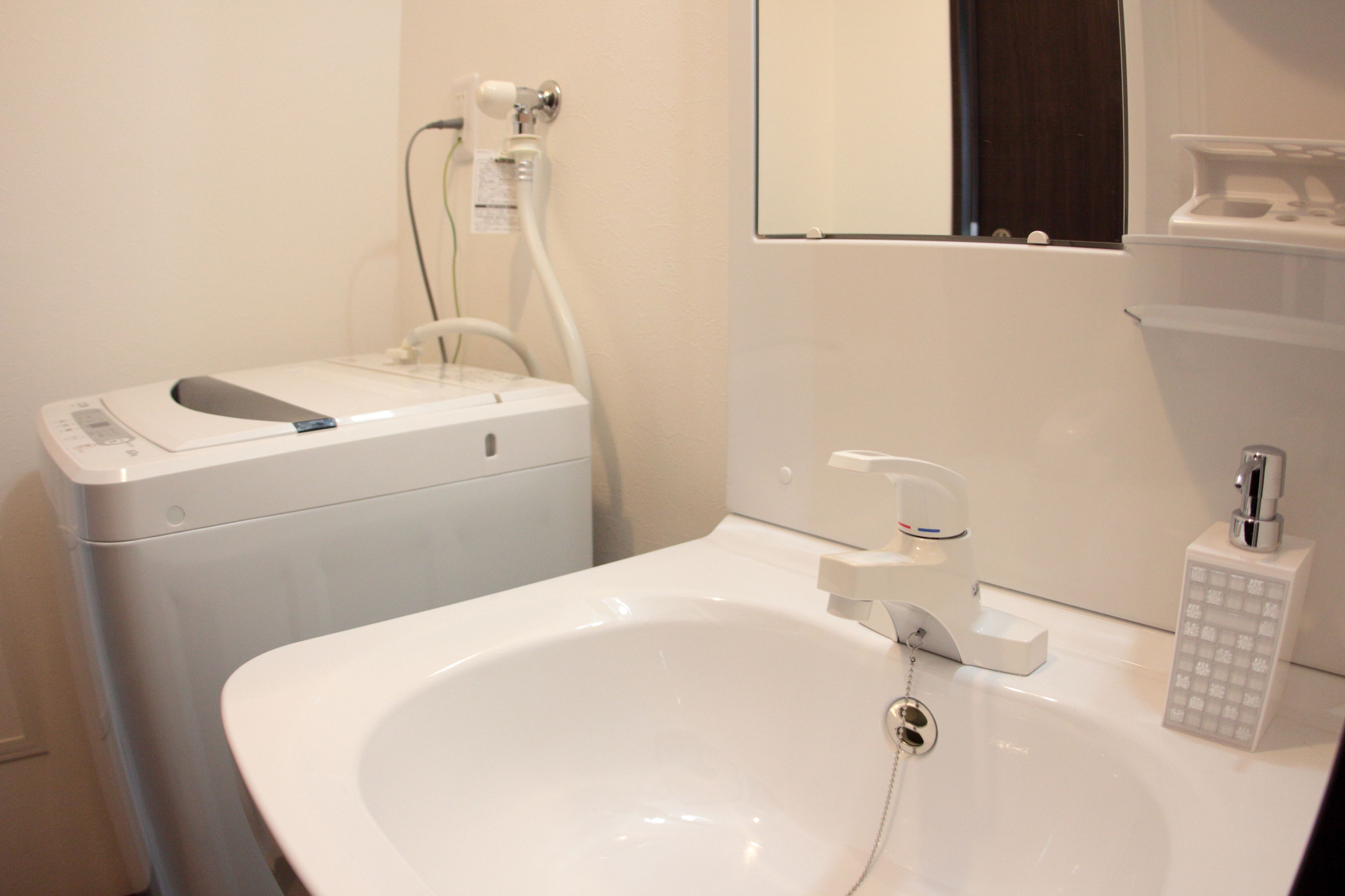 Un baño con un lavamanos blanco, un inodoro y un espejo.