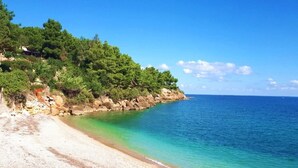 A coastal beach with clear turquoise waters, a pebble beach, and dense green vegetation on the hillside. - Le Vele di Balestrate (Balestrate)