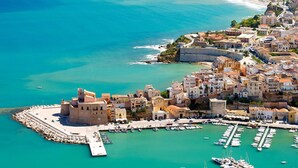 An aerial view of a coastal town with a fortified castle, marina, and dense residential area. - Le Vele di Balestrate (Balestrate)