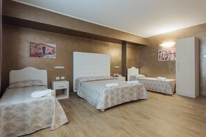 A hotel room with two single beds, a nightstand, a wardrobe, and a wall-mounted TV. - Le Vele di Balestrate (Balestrate)