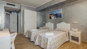 A hotel room with two beds, a desk, and a chair. There is a painting on the wall and a phone on the bedside table. - Le Vele di Balestrate (Balestrate)