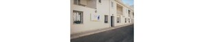 A row of buildings with balconies, a paved street, and a sign on the wall. - Le Vele di Balestrate (Balestrate)