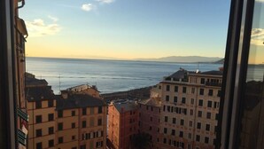 A view from a window overlooking a coastal cityscape with buildings and a body of water. - House Camogli (Camogli)