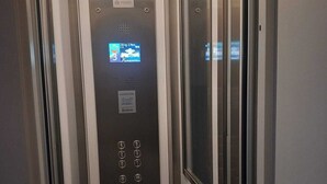 An elevator interior with a digital display, control panel, and emergency buttons. - House Camogli (Camogli)