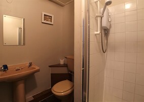 Een badkamer met een wastafel, toilet en douche.