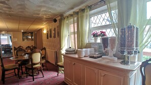 A dining area with a counter, chairs, and a window with curtains. - The Hopton Hotel (Blackpool)