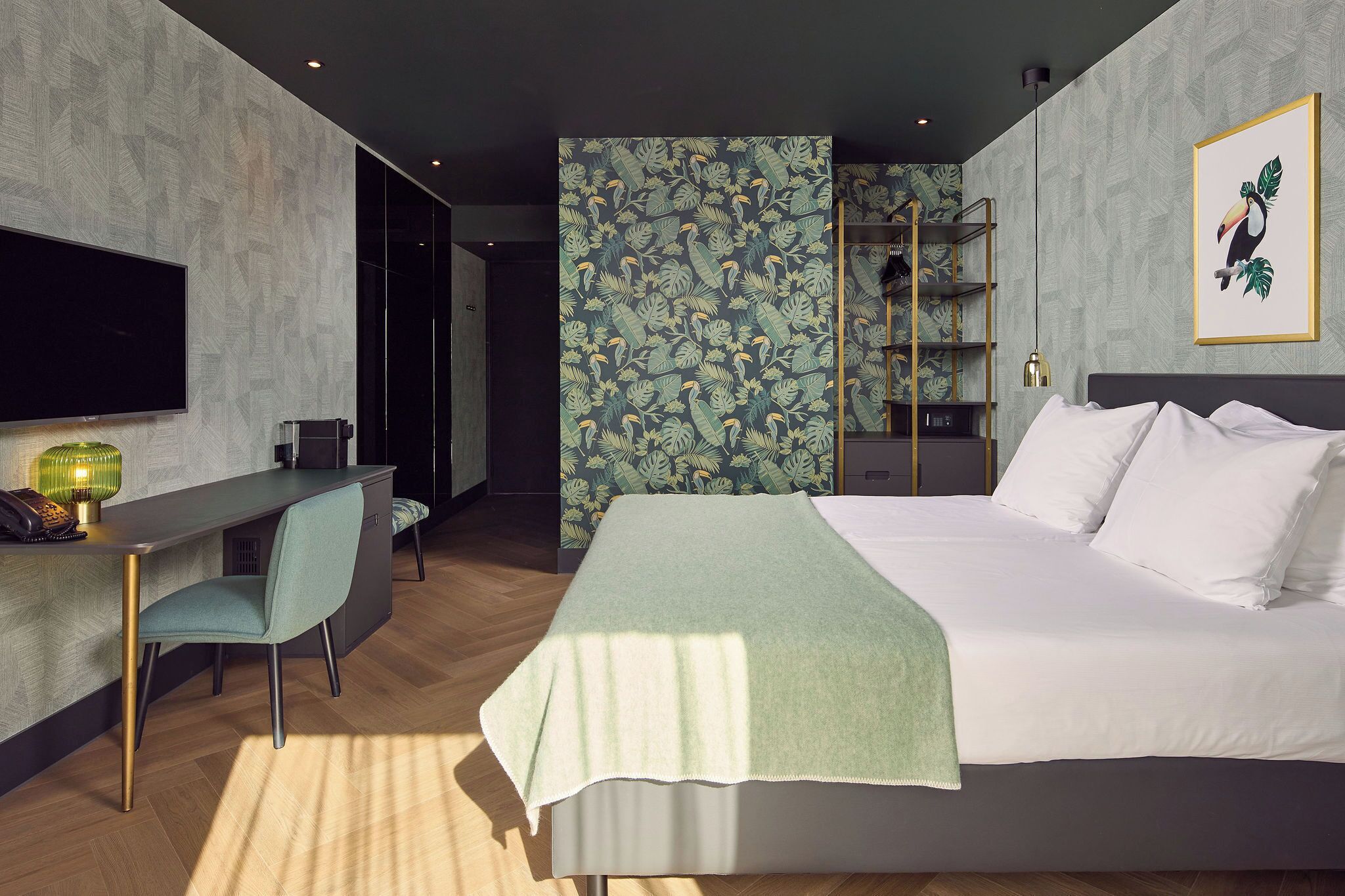 Una habitación de hotel moderna con cama, escritorio, silla y televisor.