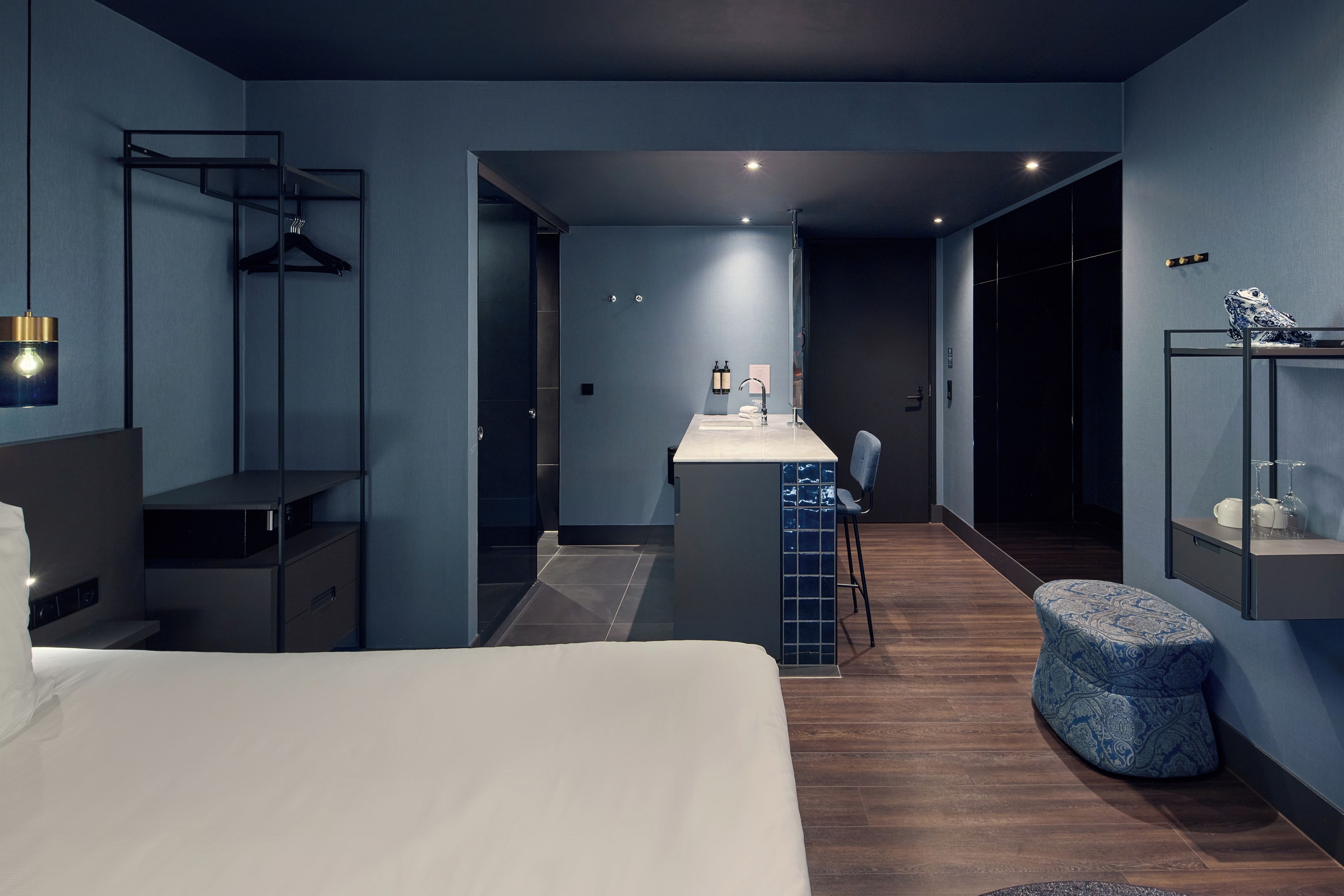 Une chambre d’hôtel moderne équipée d’un lit, d’un bureau, d’une chaise et d’un petit coin salon.