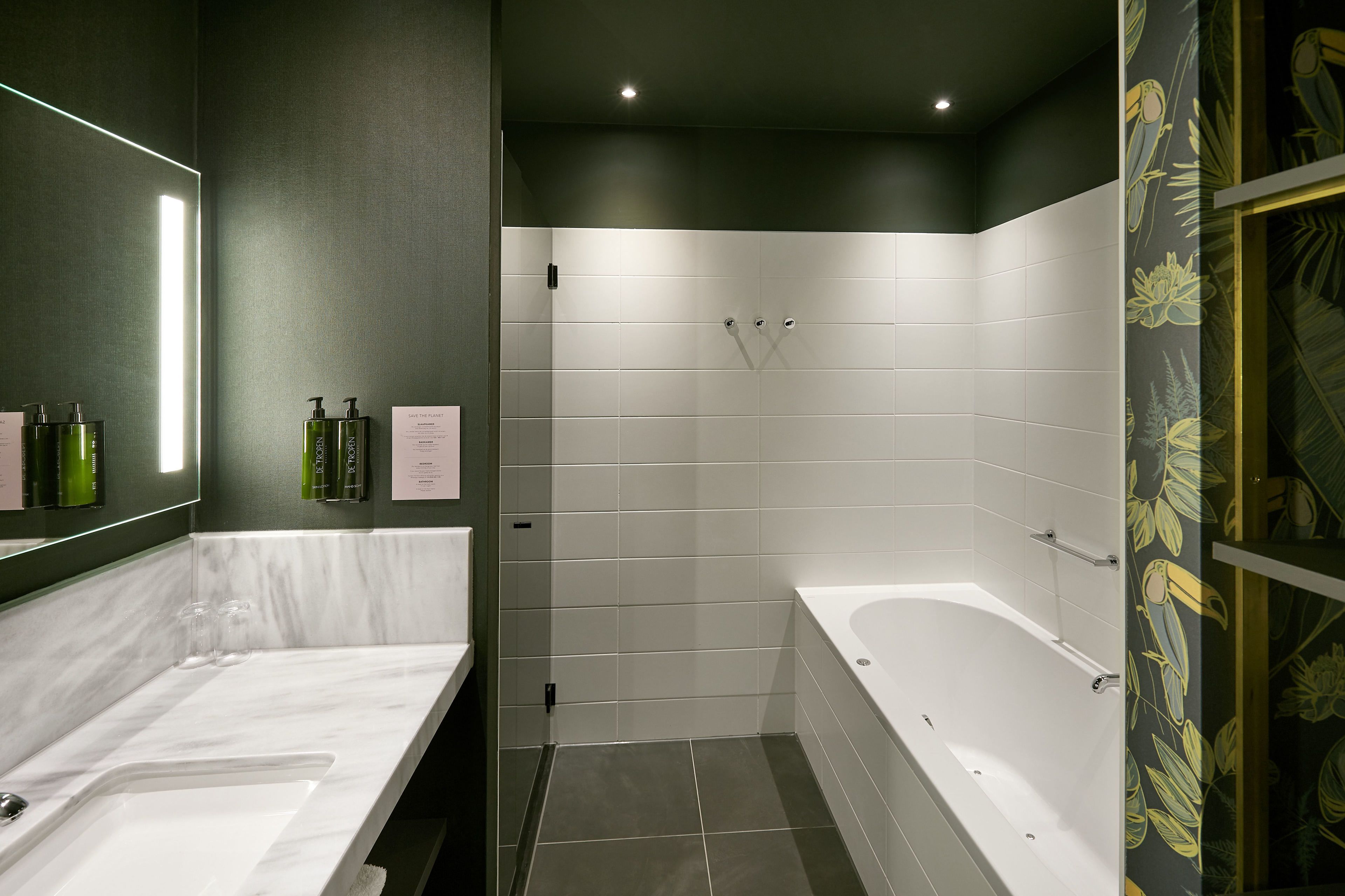 Un baño moderno con un espejo grande, dos lavamanos, una bañera y una zona de ducha.