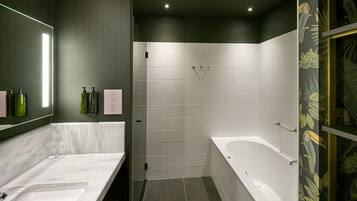 Un baño moderno con un espejo grande, dos lavamanos, una bañera y una zona de ducha.