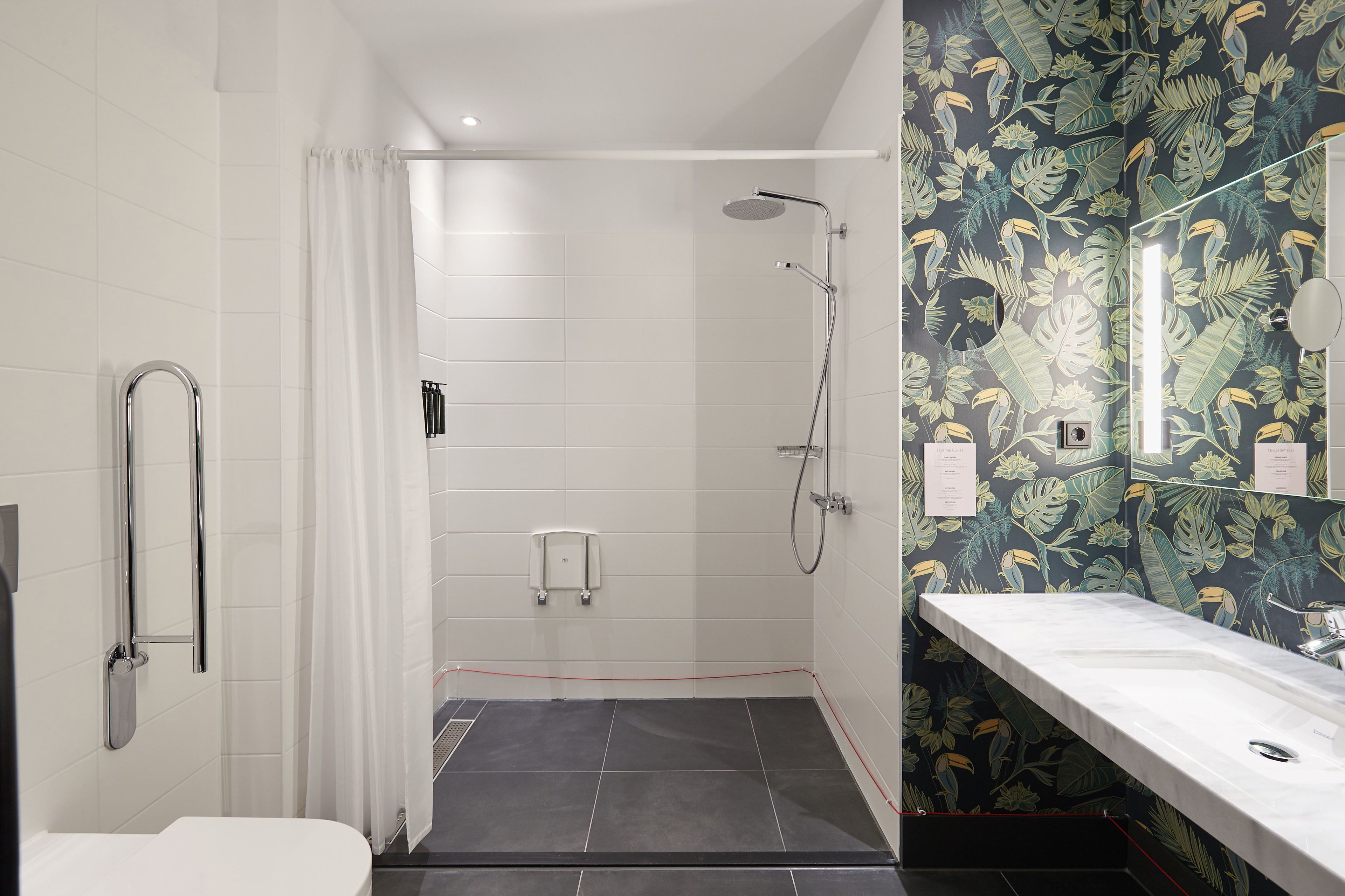 Een badkamer met douche, toilet en wastafel.