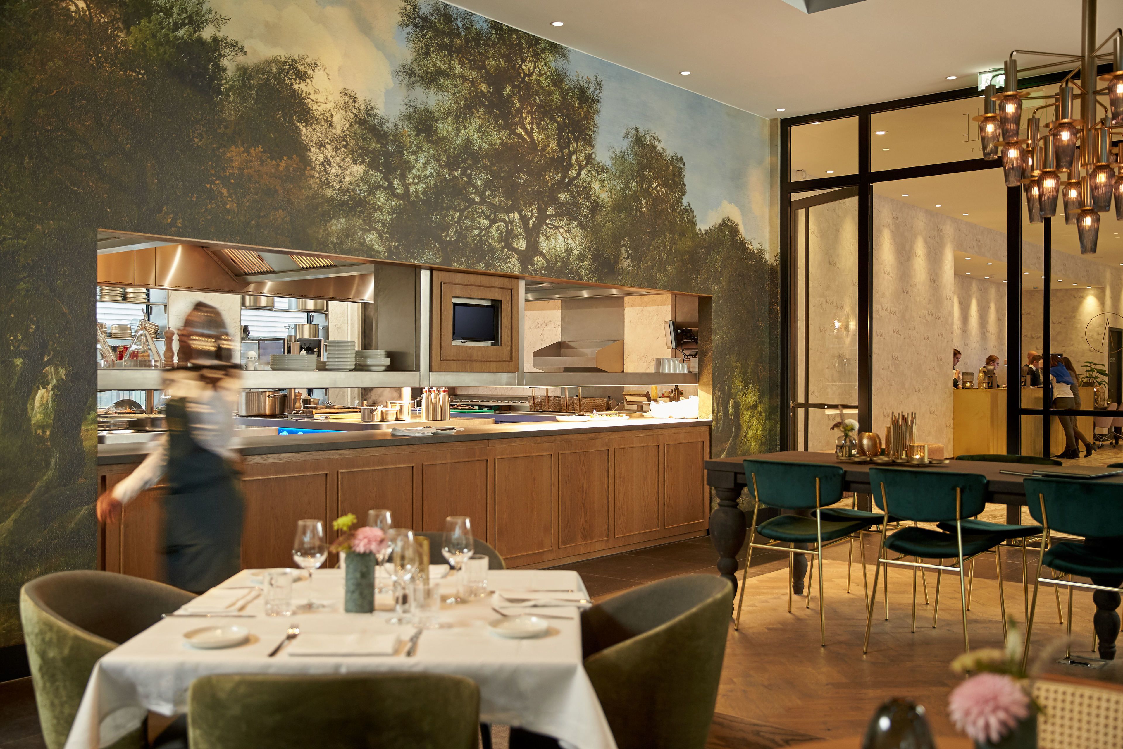 Un restaurante moderno con zona de comedor, cocina y amplios ventanales.