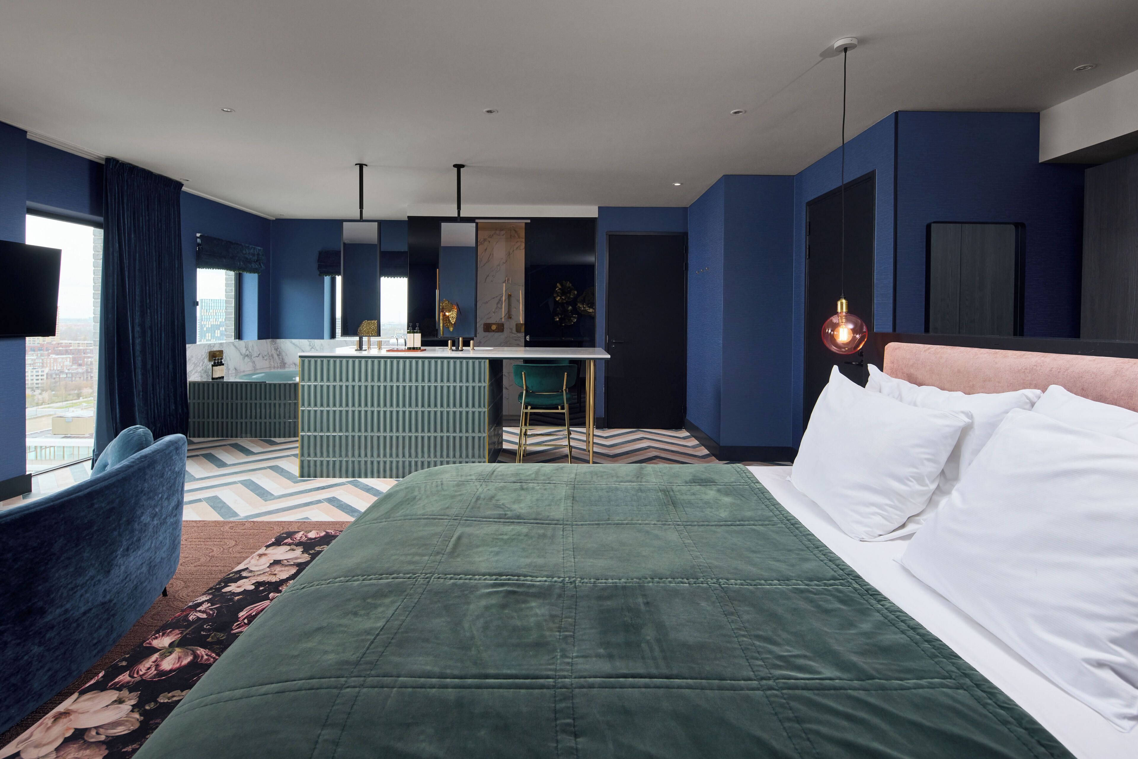 Una habitación de hotel moderna con una cama grande, un escritorio y vistas a la ciudad.