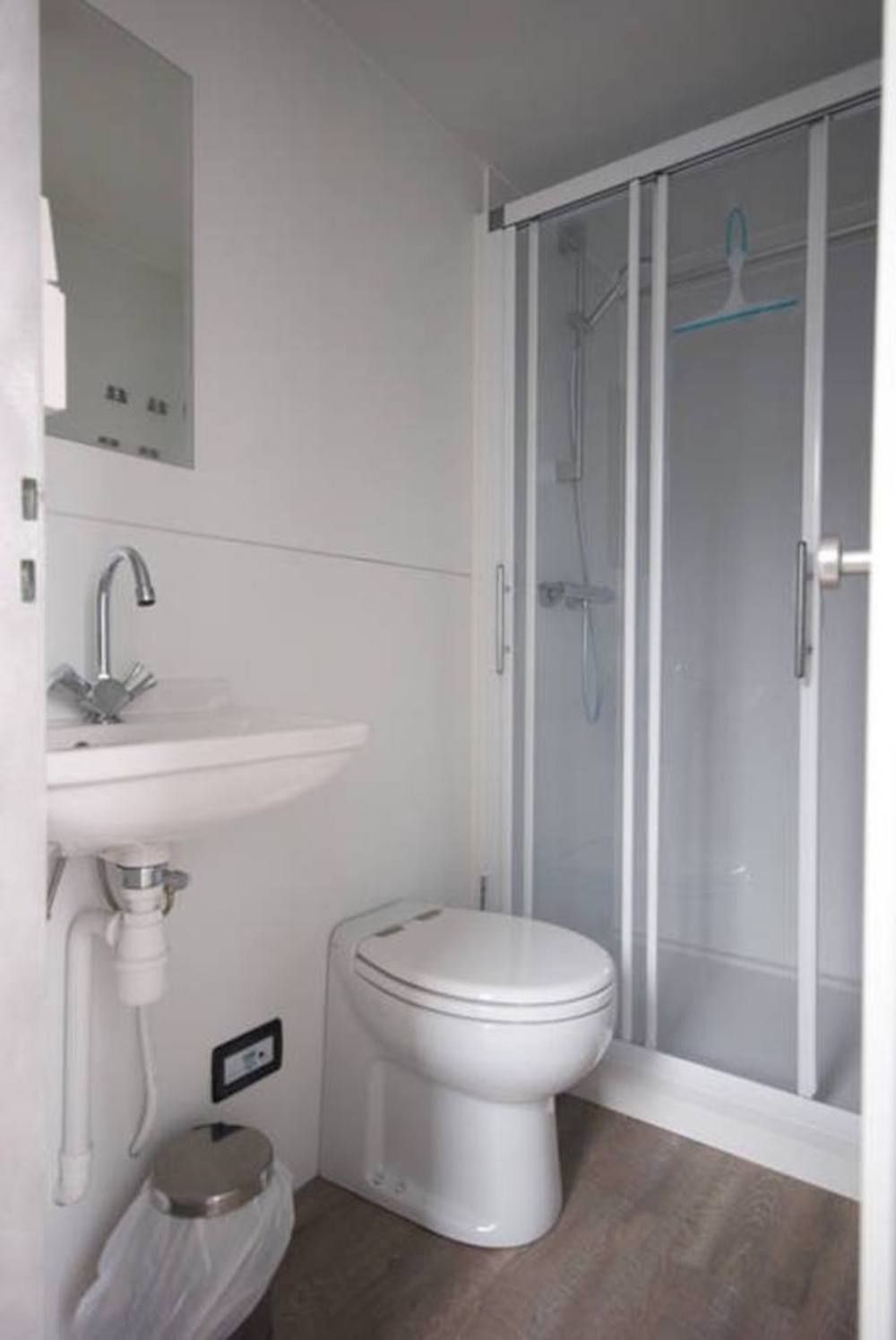 A bathroom with a toilet, sink, and shower enclosure.