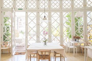 A bright, open room with a white table and chairs, a star-shaped mat at the entrance, and a sign reading "SORTIDA".