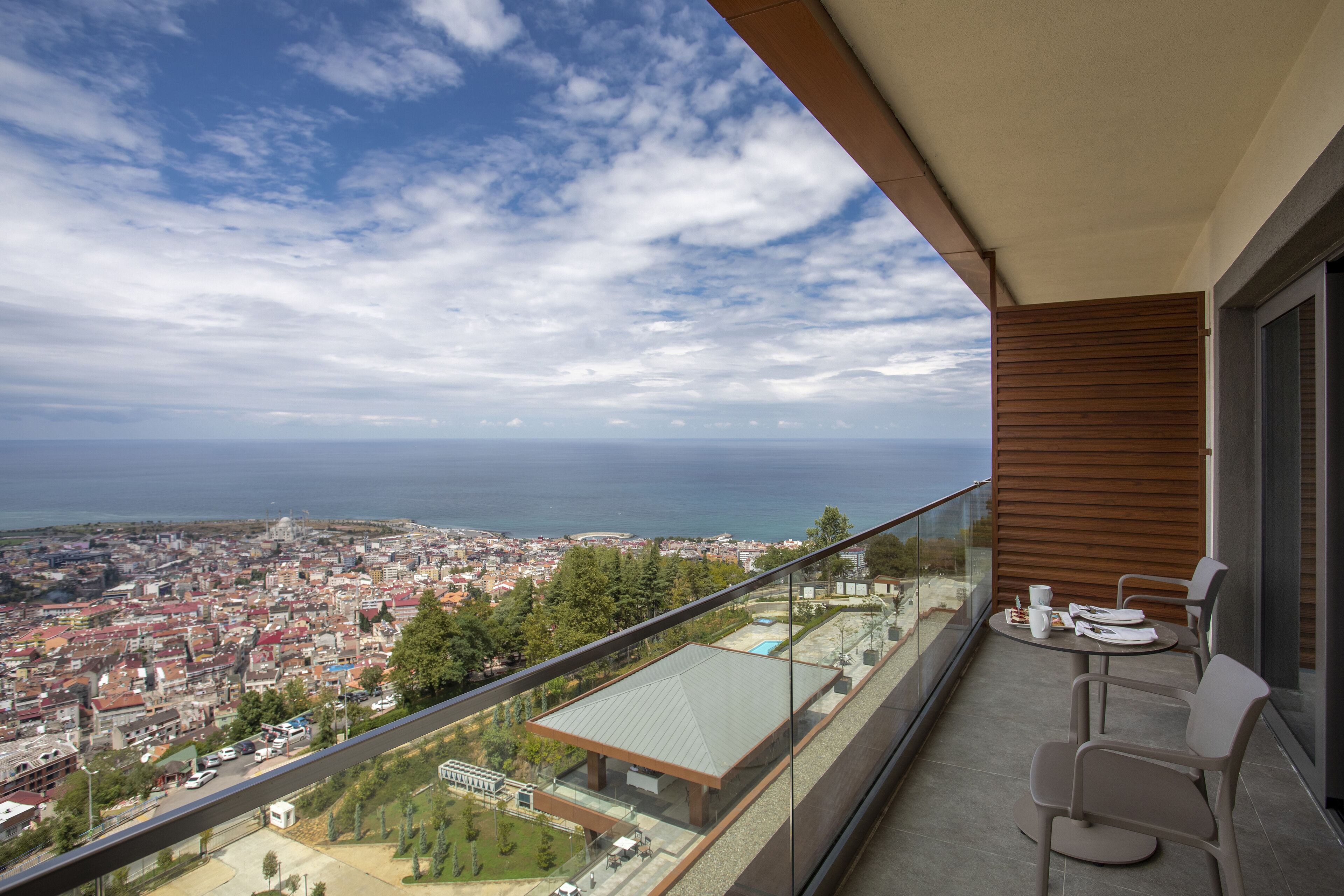 A balcony with a view of a city and the sea.