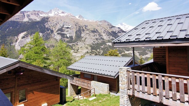 A wooden cabin with a stone foundation, a balcony, and a mountain view. - Chalet in La Norma near Ski Lifts (La Norma)