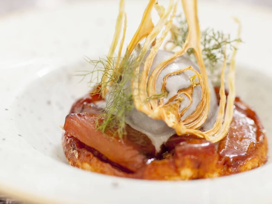 Un plat dont la base est croustillante, garni d’herbes et de fines lamelles d’oignon.
