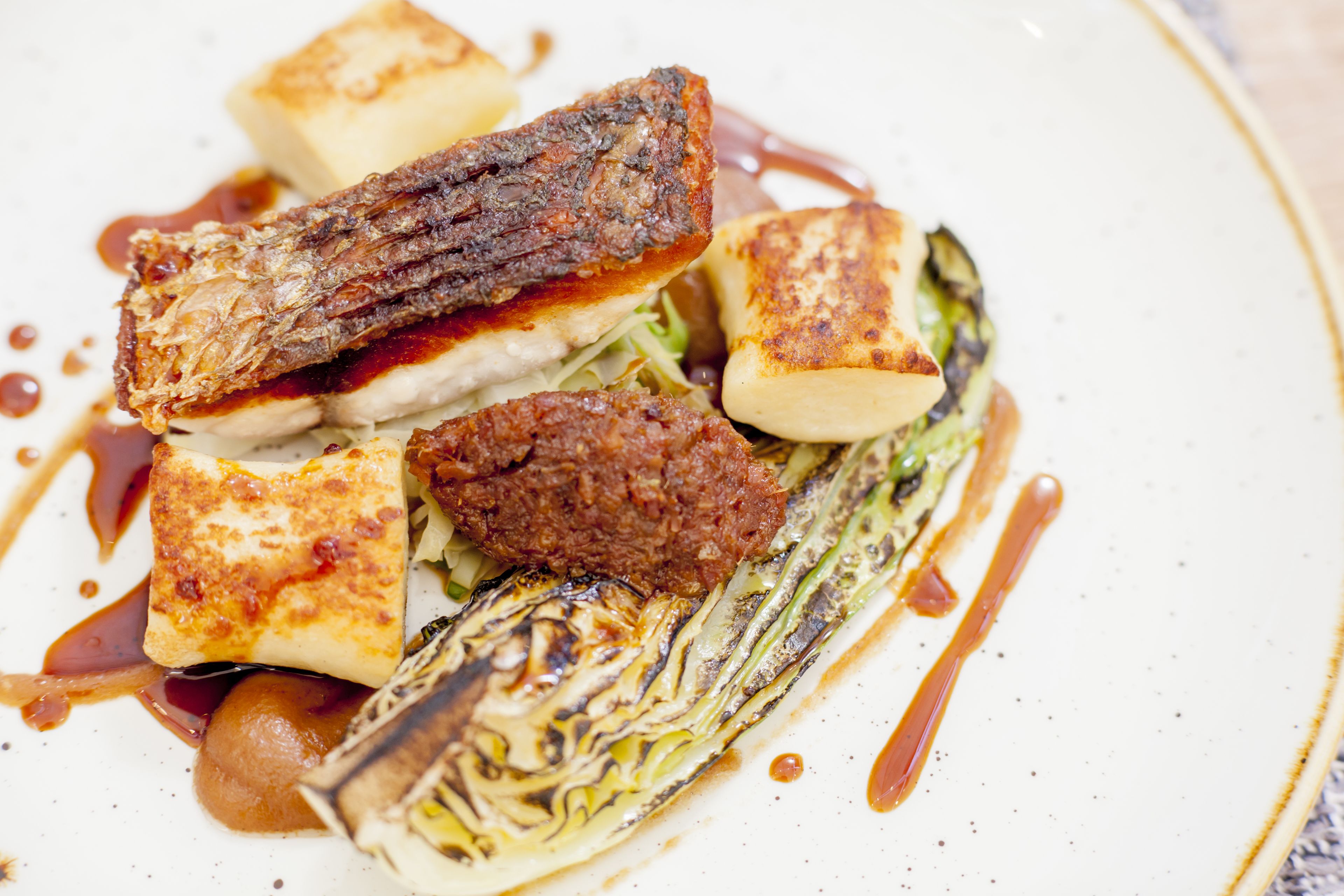 A plate of food with grilled meat, tofu, and vegetables.