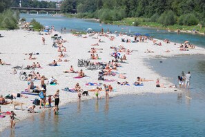 A crowded riverside beach with people sunbathing and swimming. - Romantic apartment in a quiet location, close to city center and Oktoberfest. (München (Thalkirchen-Obersendling))