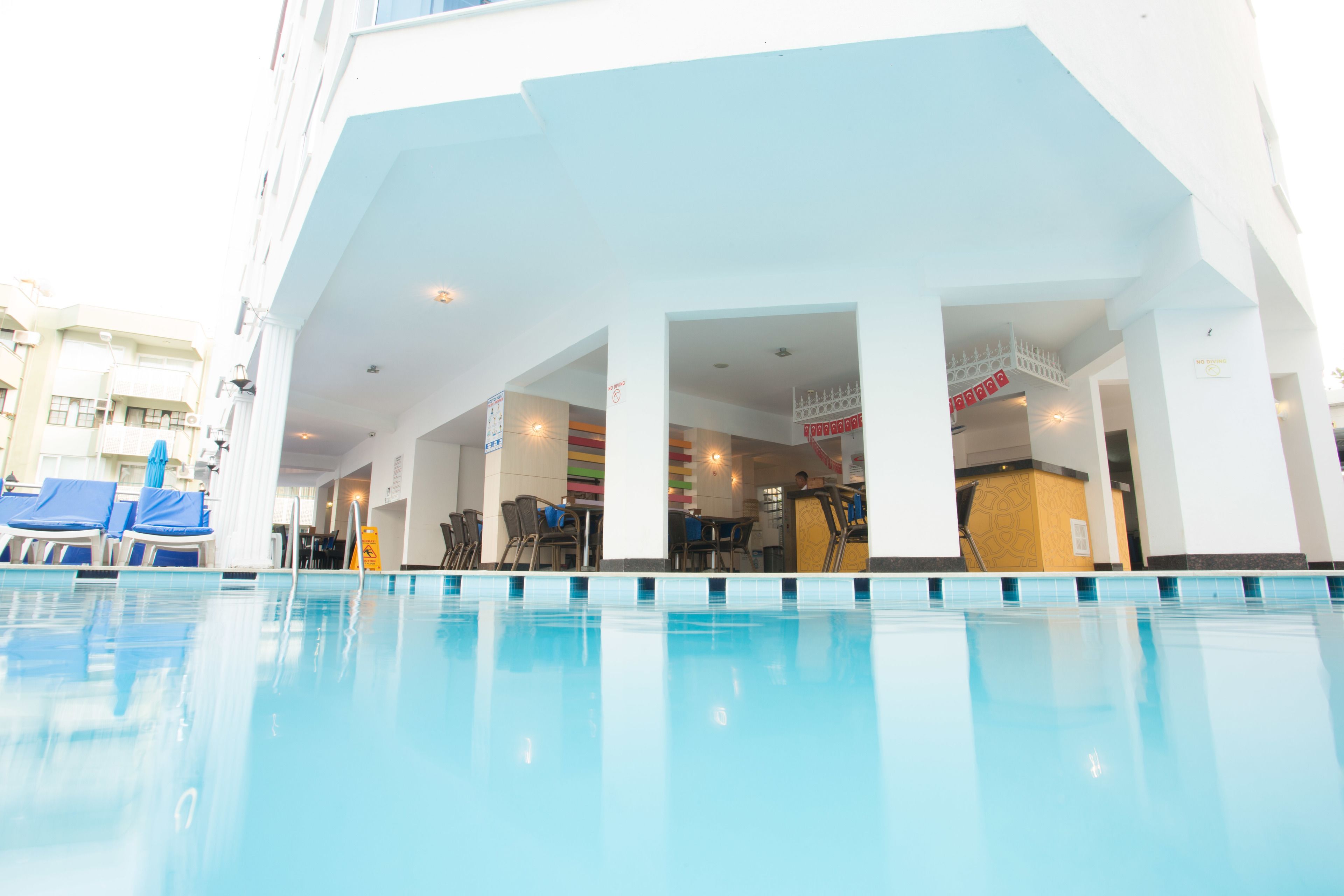 Una piscina al aire libre, sillones reclinables de piscina