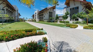 A modern hotel with a central courtyard, surrounded by lush greenery and palm trees. - MLW203 Flat at beach Muro Alto 6 people (Ipojuca)