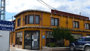 Un edificio amarillo con un letrero que dice "HOTEL RESTAURANTE EL MANO".