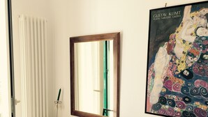 A bedroom with a bed, a desk with a chair, a mirror, and a painting on the wall. - House in historic villa absolute tranquility sea and center Naples (Napoli)