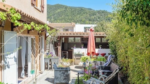 A courtyard with outdoor seating, a pergola, and a mountain backdrop.