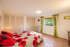 A bedroom with a bed, a radiator, a window with curtains, and a radiator on the wall. - Homerez - House in Arles sur Tech (Arles sur Tech)