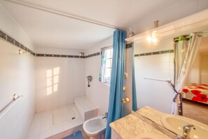 A bathroom with a shower, toilet, and sink.