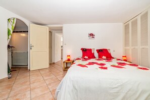 A bedroom with a bed, two bedside lamps, a radiator, and a wardrobe. - Homerez - House in Arles sur Tech (Arles sur Tech)