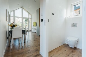Ein modernes Badezimmer mit Toilette, Dusche und Fenster.