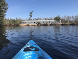 Un kayak sobre aguas tranquilas con un edificio al fondo.