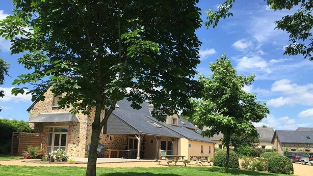 A stone building with a sloped roof, surrounded by a well-maintained lawn and trees. - Domaine des Mille Oiseaux - Colibris (Villiers-Charlemagne)