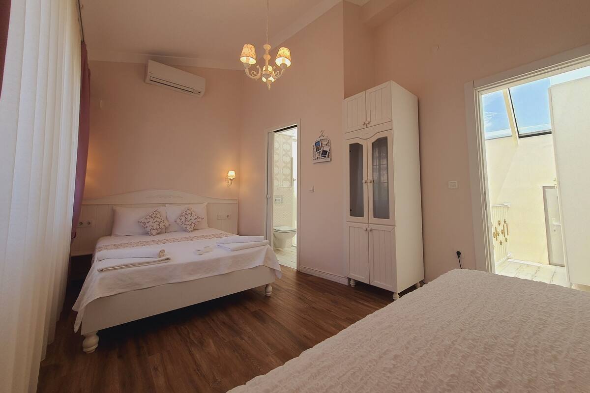 Un dormitorio con cama, armario, candelabro y ventana.