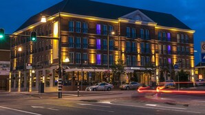 Un hotel de varios pisos con fachada de ladrillo y ventanas iluminadas.