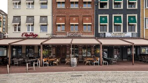 En restaurang med uteservering, en skylt med texten ”Sancho’s” och en skylt med texten ”Hotell” ovanför.