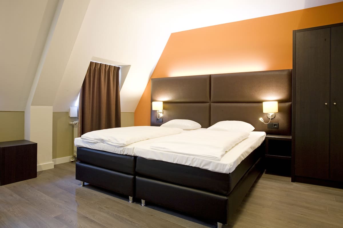 Un dormitorio moderno con una cama grande, dos lámparas de noche y un armario.