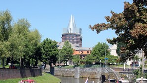 En kanal med båtar, en bro och en karaktäristisk byggnad med ett torn i bakgrunden.