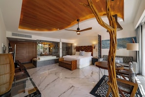Een moderne hotelkamer met een groot bed, een zithoek, een badkamer en uitzicht op de bergen.