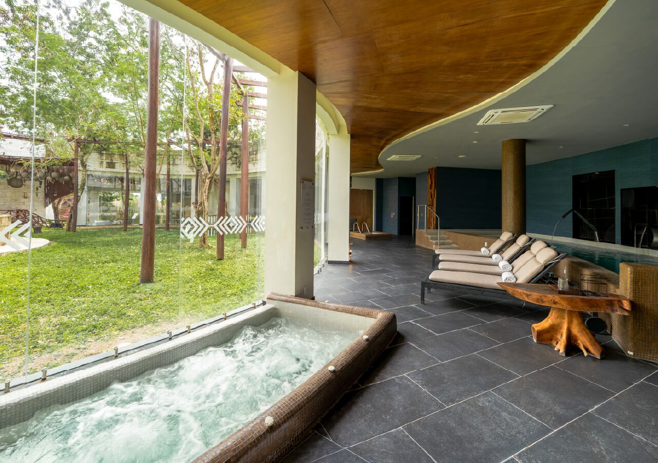 Un espacio de spa con hidromasaje, sillones de descanso y vistas al exterior.