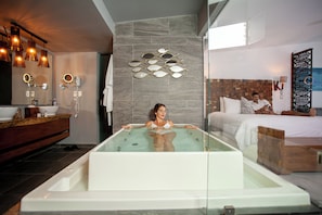 A modern bathroom with a glass-enclosed jacuzzi, a wooden vanity, and a large mirror. - Mia Bacalar Luxury Resort & Spa (Bacalar)
