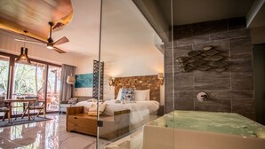A modern hotel room with a large bed, a glass-enclosed jacuzzi, and a view of the outdoors.