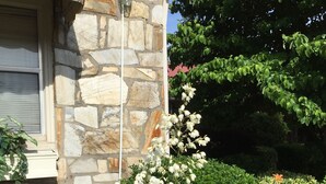 Un edificio de piedra con una ventana y una lámpara en la pared.