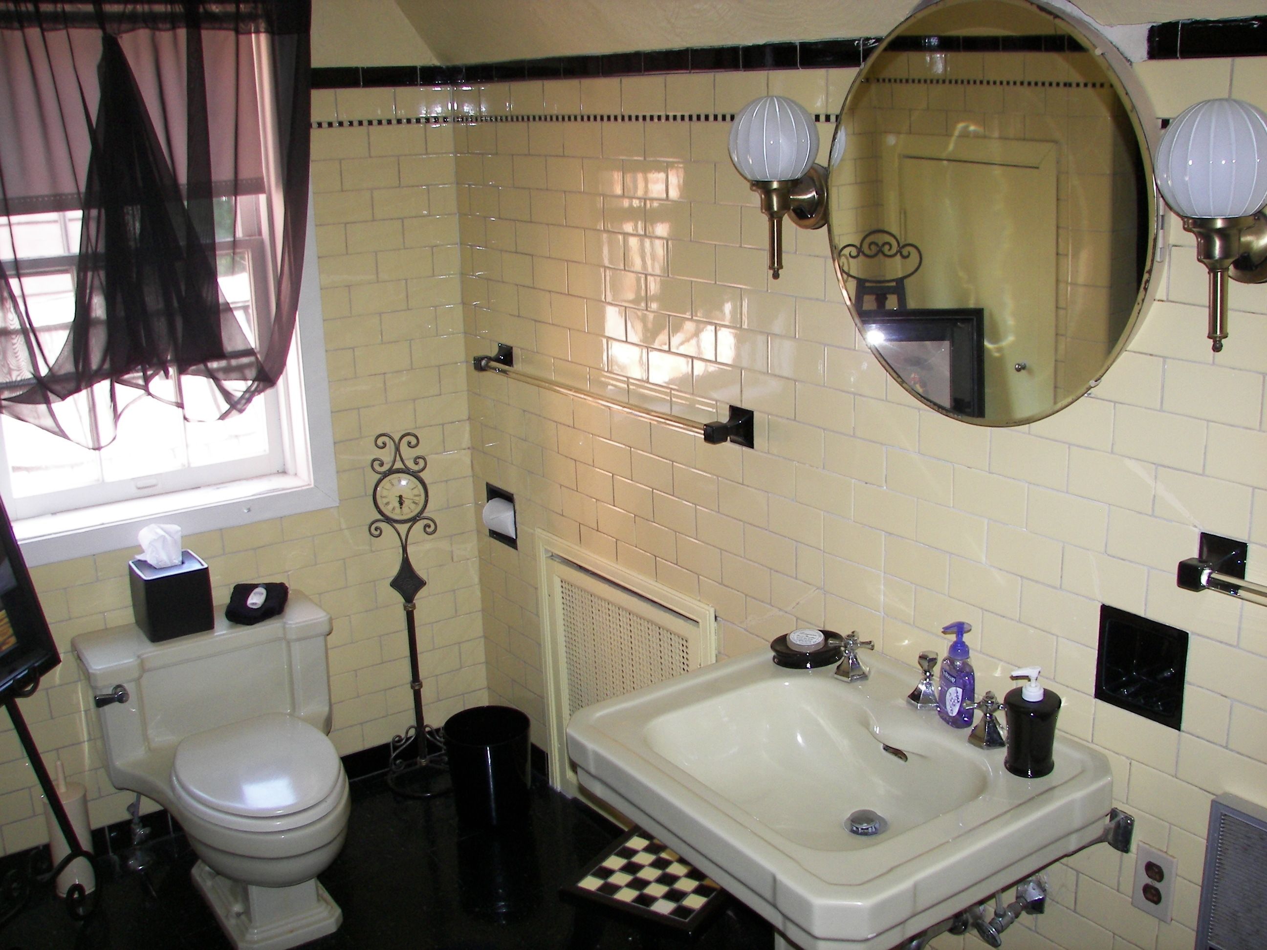 Een badkamer met toilet, wastafel en spiegel.